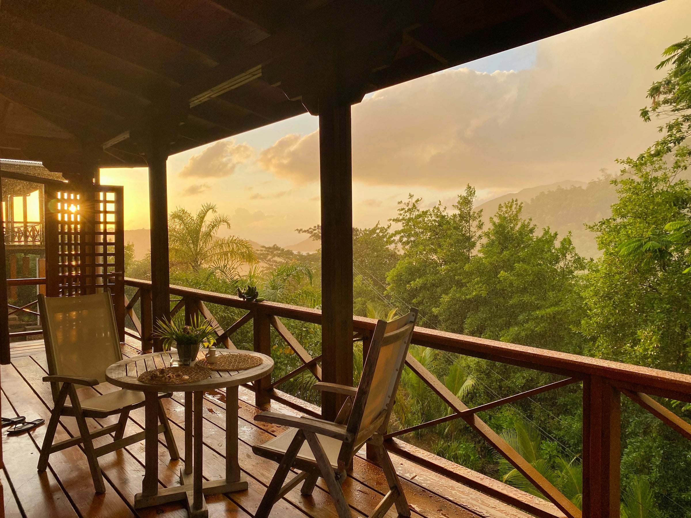 A quiet retreat balcony overlooking jungle at golden hour